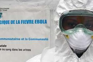 Un travailleur de santé pose devant des instructions concernant Ebola. © AFP