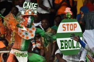 Des supporteurs brandissant un panneau Stop Ebola. © AFP