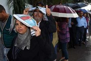 File d’attente, dimanche, devant un bureau de vote à Tunis. © AFP