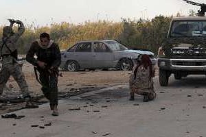 Des membres des forces armées libyennes tirent en direction de milices islamistes. © AFP