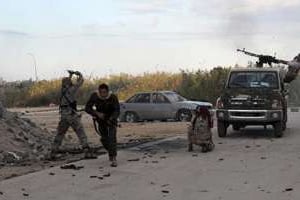 Des membres des forces armées libyennes tirent en direction de milices islamistes, le 3 novembre. © AFP