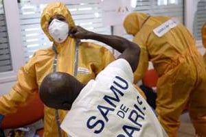 Du personnel médical s’équipent avec une tenue de protection contre Ebola, à Paris. © AFP