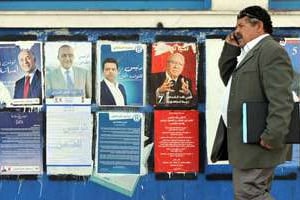 Un homme devant les affiches de la campagne présidentielle, à Tunis, le 20 novembre 2014. © Fethi Belaid/AFP