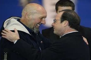 Serge Lazarevic (à gauche) embrasse le président François Hollande sur le tarmac de Villacoublay © AFP
