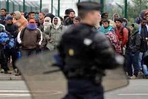 Des policiers face au migrants de Calais qui tentent de se rendre en Grande-Bretagne, en mai 2014 © AFP