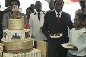 Robert Mugabe découpant son gâteau d’anniversaire en 2013. © AFP