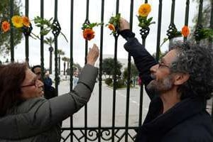 Des Tunisiens accrochent des fleurs sur les grilles du musée du Bardo à Tunis, 24 mars 2015. © Fadel Senna/AFP