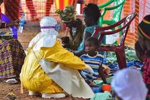 Un employé de MSF nourrit un enfant victime du virus Ebola, le 15 août à Kailahun. © AFP