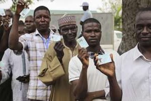 Des hommes attendent pour voter à Abuja au Nigeria, le 28 mars 2015. © AFP