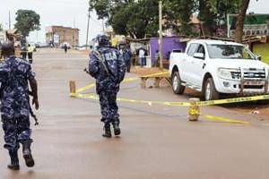À Kampala, la police surveille la voiture de la procureure Joan Kagezi, abattue la veille. © Isaac Kasamani/AFP