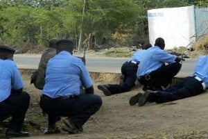 Des policiers kényans s’abritent à proximité de l’université de Garissa, le 2 avril. © AP/Stringer