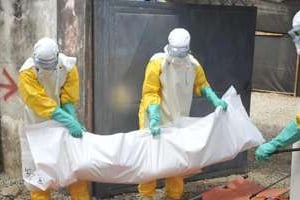 Du personnel de la Croix Rouge guinéenne retire le corps d’un patient décédé du virus de l’Ebola © AFP