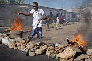 Un Burundais enjambant une barricade dans Bujumbura. © Erik Esbjornsson/AP/SIPA
