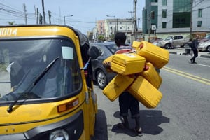 Un homme transporte des jerrycans d’essence vides à Lagos au Nigeria. © Pius Utomi Ekpei/AFP