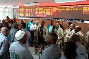 En gilet vert, les vendeurs, en gris, les acheteurs, devant le tableau d’affichage des transactions de l’Ethiopia Commodity Echange. © Grégoire Pourtier