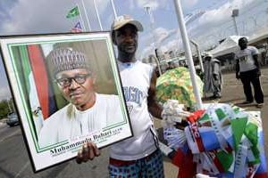 Un homme vend le 28 mai 2015 dans les rues d’Abuja une photo de Buhari. © AFP
