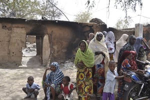 Des femmes et des enfants près d’une maison incendiée par Boko Haram, le 26 mai 2015. © Jossy Ola/AP/SIPA