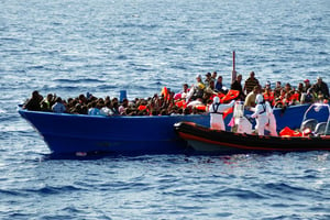 Une équipe du Migrant Offshore Aid Station (MOAS) secourt une embarcation de migrants en Méditerranée, le 8 septembre 2014. © AFP/MOAS
