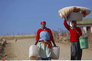 Des femmes vont chercher de l’eau à Mvezo, en Afrique du Sud, le 13 juin 2013. © Schalk van Zuydam/AP/SIPA