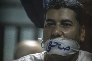 L’Egyptien Ibrahim al-Darawi, la bouche recouverte d’un bâillon sur lequel est écrit « journaliste », pendant son procès près du Caire, le 2 juin 2015. © Khaled Desouki/AFP