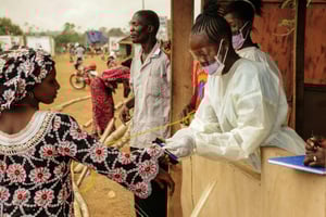 Des professionnels de santé contrôlent les passagers en transit vers le Liberia, à Jendema, au Sierra Leone, le 28 mars 2015. © Zoom Dosso/AFP