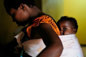 Une rwandaise portant son fils sur le dos à Kigali, le 2 septembre 2010. © Shannon Jensen/AFP