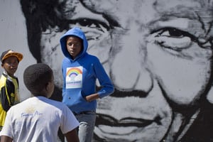 Trois jeunes sud-africains devant une fresque murale représentant Nelson Mandela, le  2 mai 2014 à Soweto. © Ben Curtis/AP/SIPA