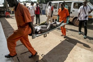 Une personne blessée, lors de violences provoquée par l’assassinat d’un conducteur de moto-taxi, arrive sur une civière à l’hôpital de Bangui, le 26 septembre 2015 en Centrafrique. © AFP