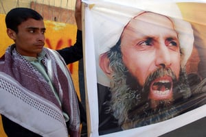 À Sanaa au Yémen, un manifestant arborant le portrait du dignitaire religieux chiite, Nimr Baqer al-Nimr en octobre 2014. © AFP