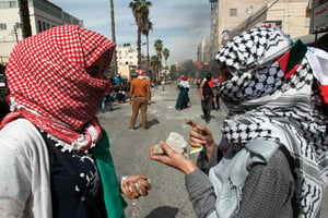 Des étudiants de l’université de Hébron rassemblent des pierres pour les jeter sur les soldats israéliens, le 13 octobre. © HAZEM BADER/AFP