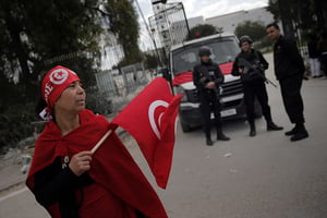 Une femme tenant le drapeau tunisien devant des policiers, deux jours après l’attentat du Bardo. © Christophe Ena/AP/SIPA