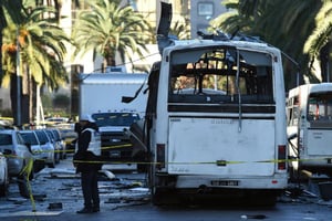 La police scientifique tunisienne inspecte les débris d’un bus après l’attentat du 25 novembre 2015 à Tunis. © AFP