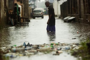 Un homme dans une rue inondée de Kinshasa. © AFP