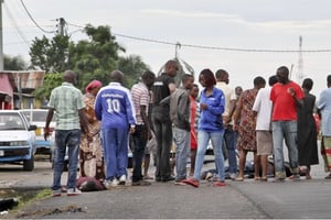 Des passants du quartier de Nyakabiga se rassemblent autour de cadavres, le 12 décembre 2015. © AP/SIPA