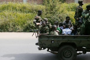 Un véhicule militaire transporte des hommes les mains liées, le 11 décembre 2015 à Burumbuja. © Stringer/AFP