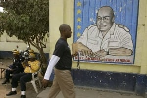 Un Cogolais passe devant un portrait mural de Lauren-Désiré Kabila, le 9 août 20016 à KInshasa. © MICHEL EULER / AP / SIPA