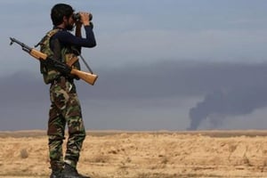 Un combattant kurde observe la bataille contre les forces du groupe Etat islamique près de Tikrit, en Irak, le 8 mars 2015 © Ahmad Al-Rubaye/AFP