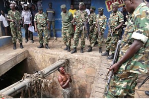 Un homme suspecté d’appartenir aux Imbonerakure supplie les militaires de le protéger de la foule (Bujumbura, le 7 mai 2015). © JEROME DELAY/AP/SIPA