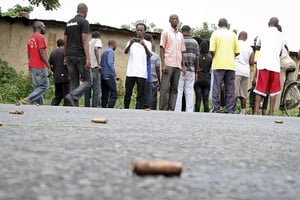 Un homme regarde des balles sur le sol dans un quartier de Bujumbura en décembre 2015. © STR / AP / SIPA