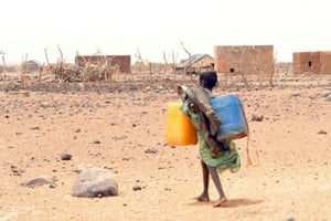 Une fillette transporte un bidon pour aller le remplir d’eau. © AFP