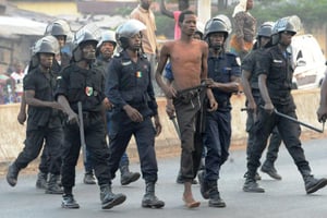 Des policiers arrêtent un manifestant à Conakry, pendant une grève générale, le 15 février 2016. © AFP