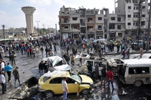 Sur le site d’un double attentat à la bombe dans le quartier Al-Zahraa de Homs le 21 février 2016. © AFP