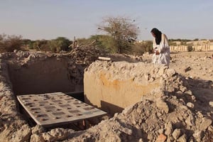 Mohamed Maouloud Ould Mohamed, chargé de l’entretien d’un mausolée de Tombouctou, se recueille le 4 avril 2014 sur l’une des tombes détruites par les terroristes. © Baba Ahmed / AP / SIPA