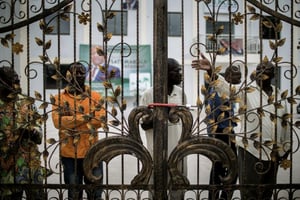 Des militants du parti d’opposition congolais UPADS derrière les grilles cadenassées du siège de leur parti, à Brazzaville, le 25 mars 2016.
