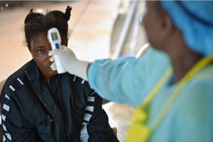 Prise de température d’une petite fille potentiellement porteuse du virus Ebola en Sierra Léone © Carl de Souza/ AFP