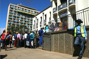 Des Zimbabwéens font la queue le 5 mai 2016 devant une banque à Harare, après l’annonce du gouvernement de plafonner les retraits de liquide et d’imprimer des billets à parité avec le dollar américain. © AFP