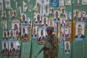 Un soldat ougandais se tient devant des affiches du leader de l’opposition Kizza Besigye après son arrestation, à Kampala, le 19 février 2016. © Ben Curtis/AP/SIPA