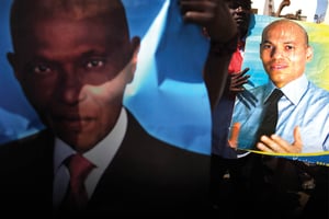 Portraits des Wade père et fils brandis lors d’une manifestation de l’opposition, à Dakar, le 23 avril 2013. © JOE PENNEY/REUTERS