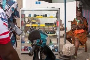 Une femme vend des téléphones portables dans le quartier commercial de Ganhi à Cotonou, au Bénin, le 26 février 2016. © Gwenn Dubourthoumieu pour J.A.
