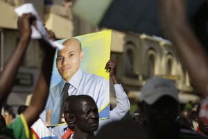Un homme brandit une photo de Karim Wade, ancien ministre et fils de l’ancien président sénégalais, lors d’une manifestation de l’opposition à Dakar, le 23 avril 2013. © Rebecca Blackwell/AP/SIPA
